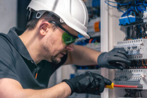 a-male-electrician-works-in-a-switchboard-using-an-2024-03-26-16-36-04-utc2.jpg